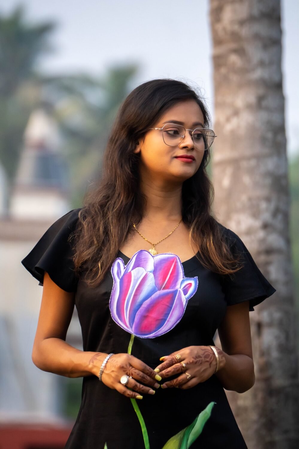 Medium close-up of 3D purple tulip handpainted artwork on a black cotton dress