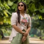 Front-facing medium shot highlighting the V-neckline and intricate cherry blossom painting on a beige asymmetrical scallop top.