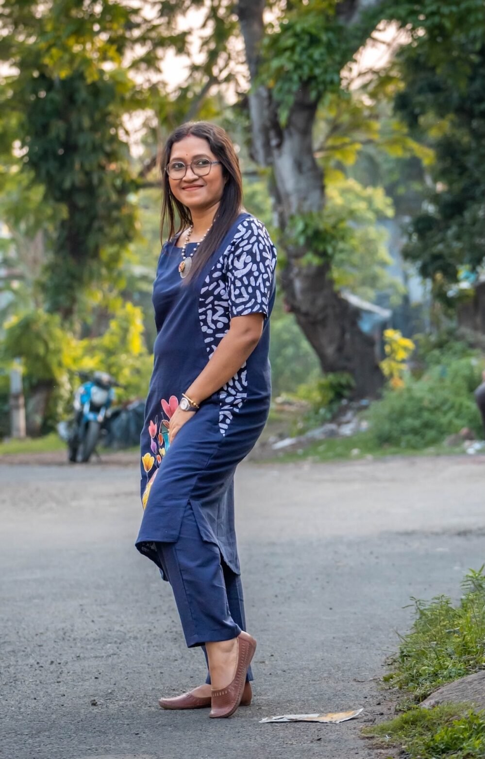 Side profile showcasing the asymmetrical batik print patchwork on the left sleeve and side panel of the navy tunic.