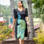 Full-length outdoor shot of a model wearing a hand painted 3D peacock Malai Cotton midi dress