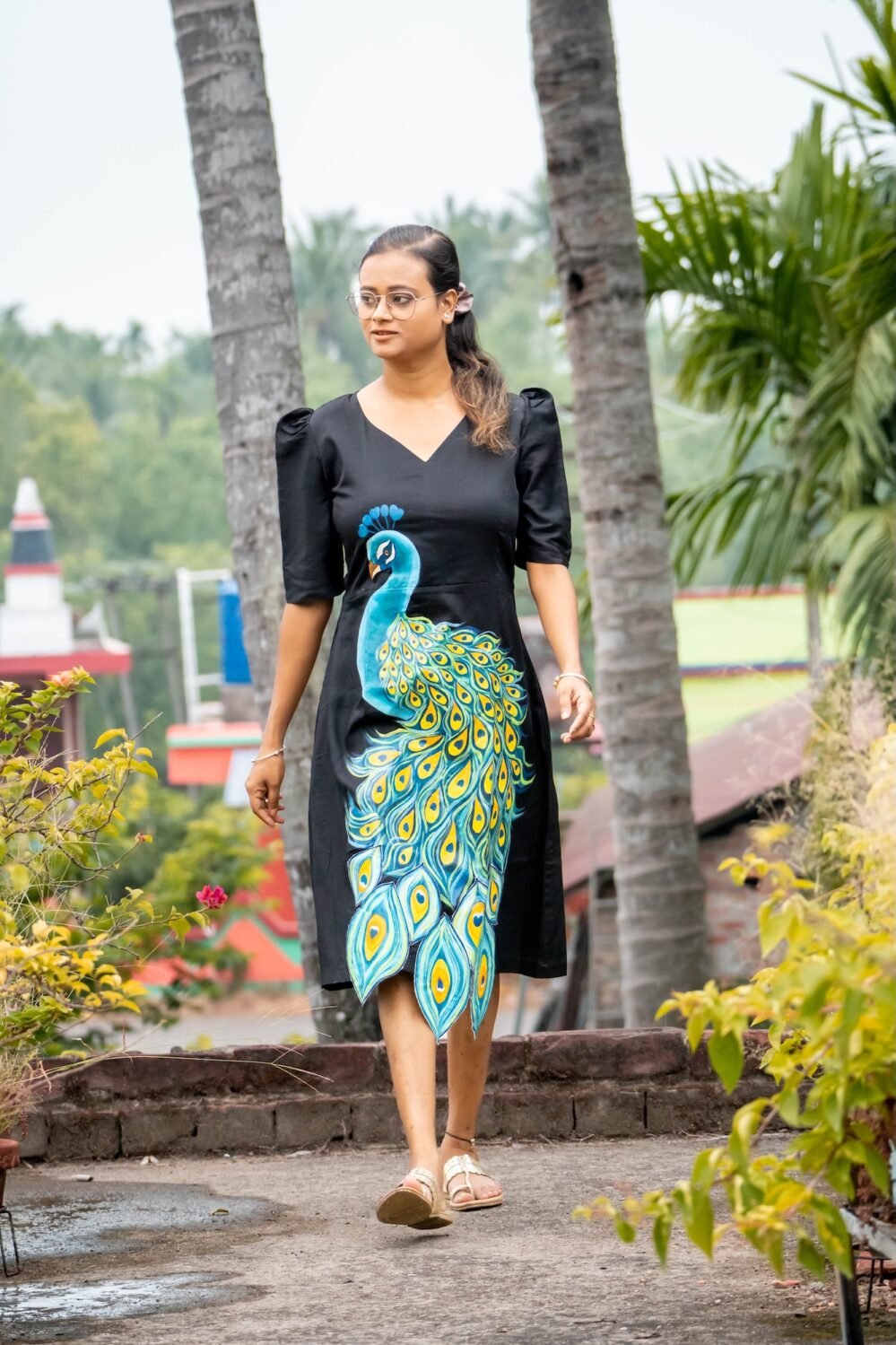 Full-length outdoor shot of a model wearing a hand painted 3D peacock Malai Cotton midi dress