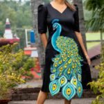 Front view of a model posing in a black hand painted 3D peacock Malai Cotton dress with puff sleeves