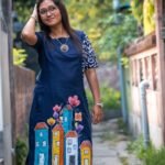 Front view of midnight blue cotton tunic featuring vibrant hand-painted house artwork at the hemline