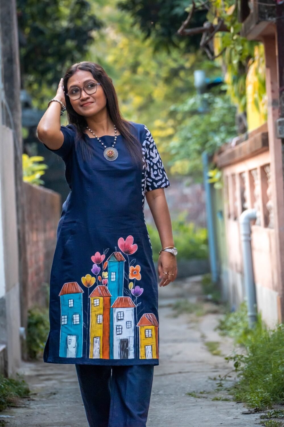 Front view of midnight blue cotton tunic featuring vibrant hand-painted house artwork at the hemline