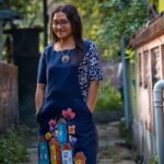 Navy blue straight cotton tunic with functional side pockets and hand-painted houses illustration.