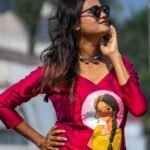 Model wearing sunglasses posing in the Nayantara magenta hand-painted portrait top and peach dhoti pant set