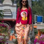 Full-length view of a model walking outdoors in the Nayantara hand-painted portrait top and floral dhoti pants