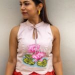 Front close-up view highlighting hand-painted lotus artwork and scalloped hem on the off-white top