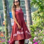 Mid-shot of model in a maroon hand-painted daisy dress and elasticated ankle pants co-ord set