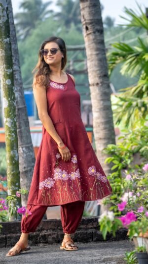 Mid-shot of model in a maroon hand-painted daisy dress and elasticated ankle pants co-ord set