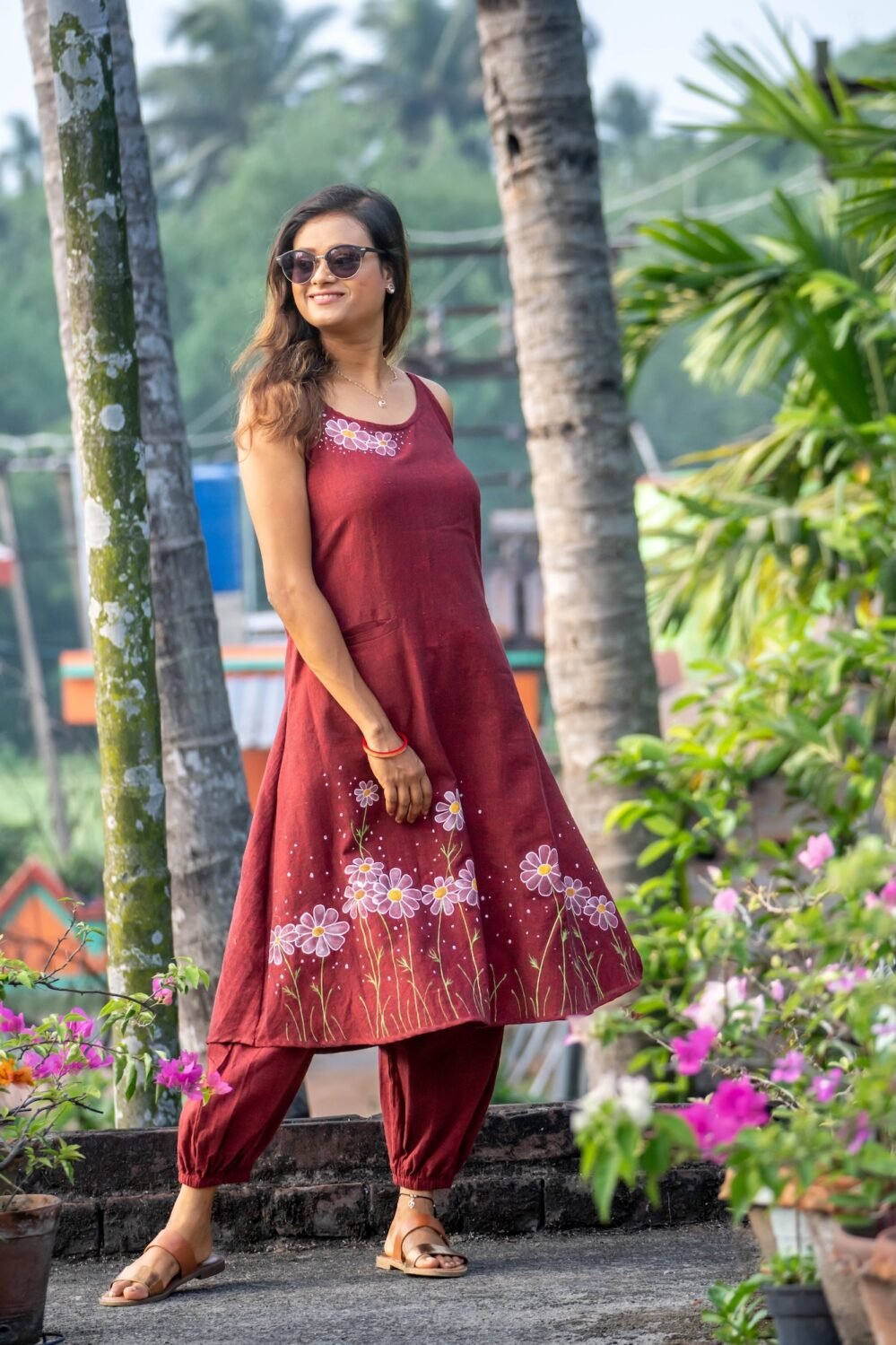 Mid-shot of model in a maroon hand-painted daisy dress and elasticated ankle pants co-ord set