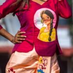 Medium shot highlighting the hand-painted Indian woman portrait artwork on the magenta top and floral vine painting on the dhoti pant