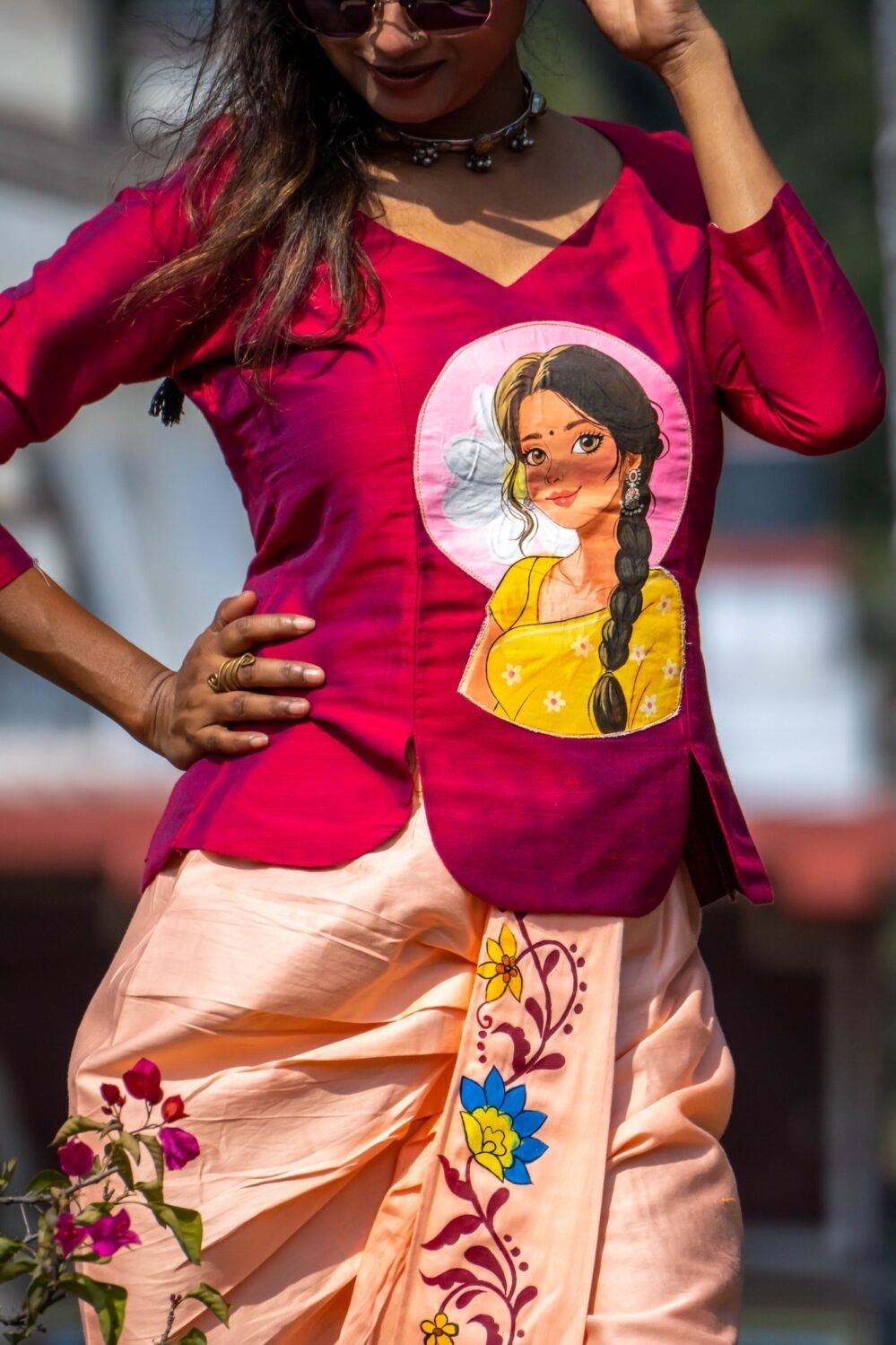 Medium shot highlighting the hand-painted Indian woman portrait artwork on the magenta top and floral vine painting on the dhoti pant