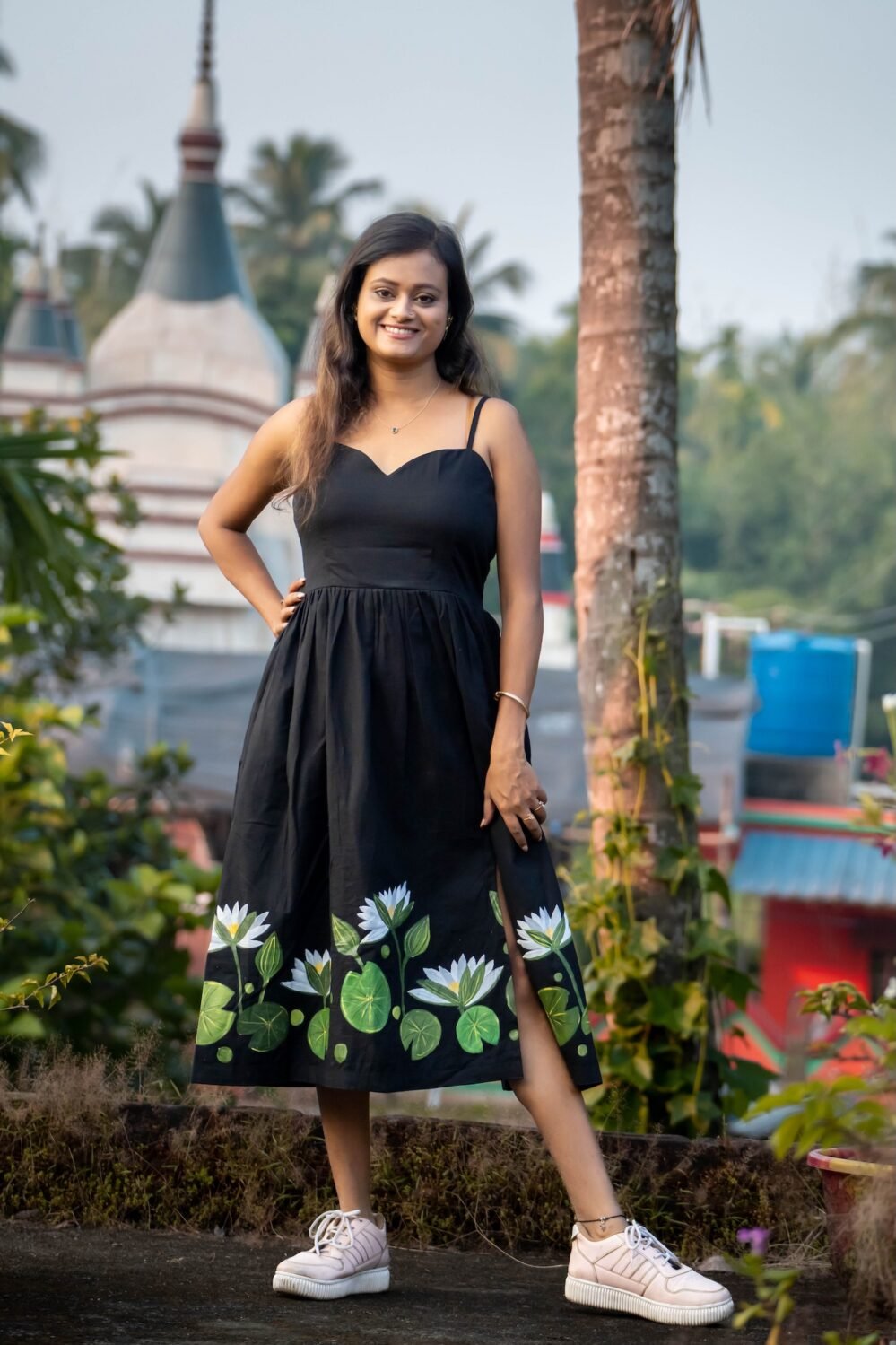 Full view of woman wearing black hand-painted floral midi dress with sweetheart neckline