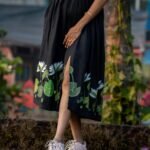 Lower body view highlighting hand-painted floral art and front slit on a black flared dress