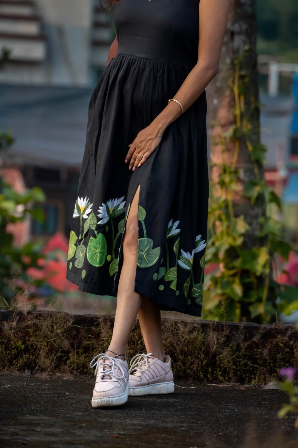 Lower body view highlighting hand-painted floral art and front slit on a black flared dress