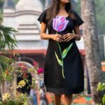 Model posing outdoors wearing a handpainted 3D purple tulip black Malai Cotton midi dress