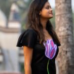 Side-angle view of model in a handpainted 3D purple tulip black Malai Cotton dress