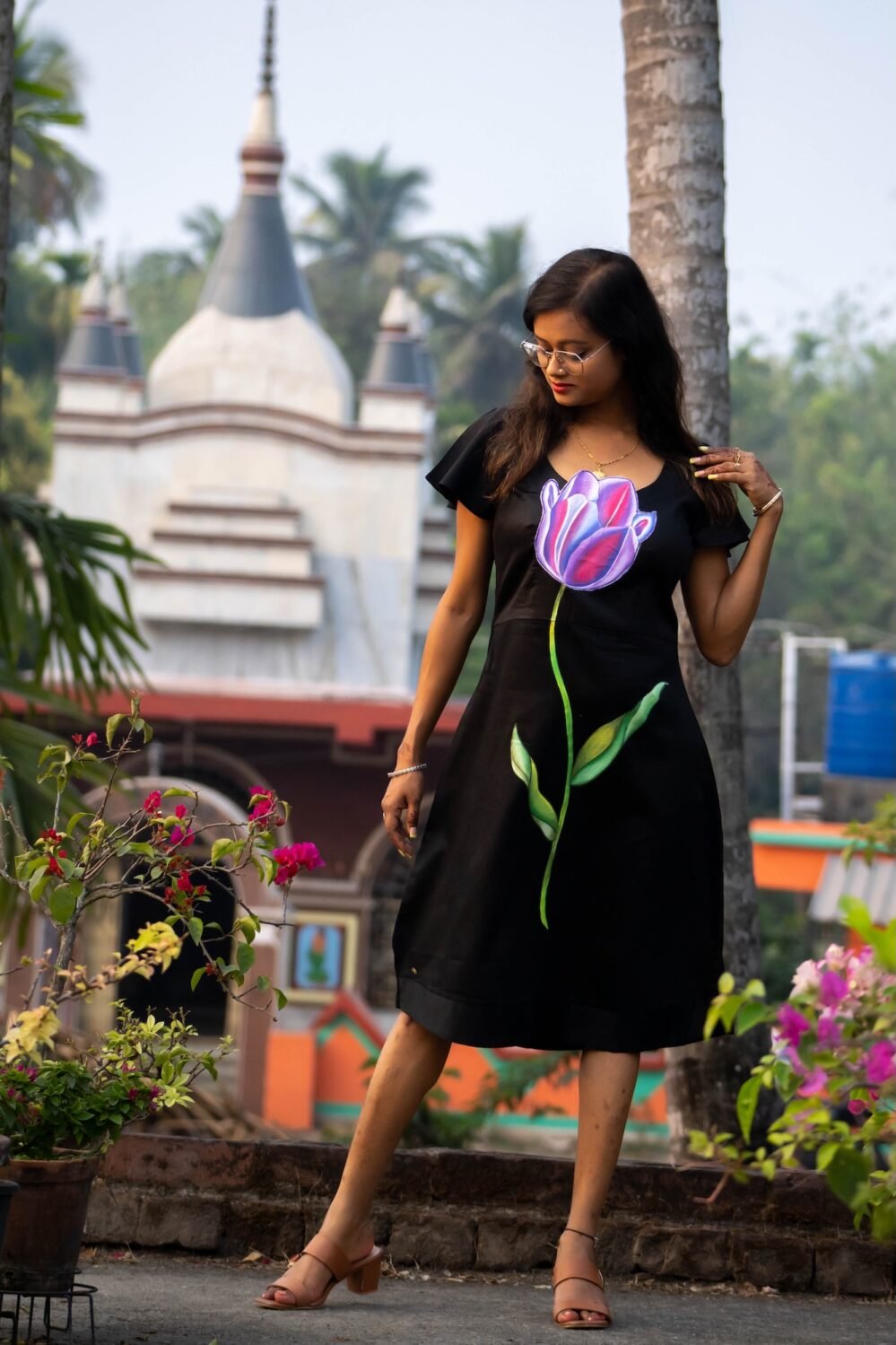 Full shot of model wearing handpainted 3D purple tulip black dress looking down