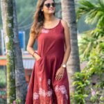 Three-quarter view of hand-painted maroon dress highlighting the functional side pocket and A-line flair