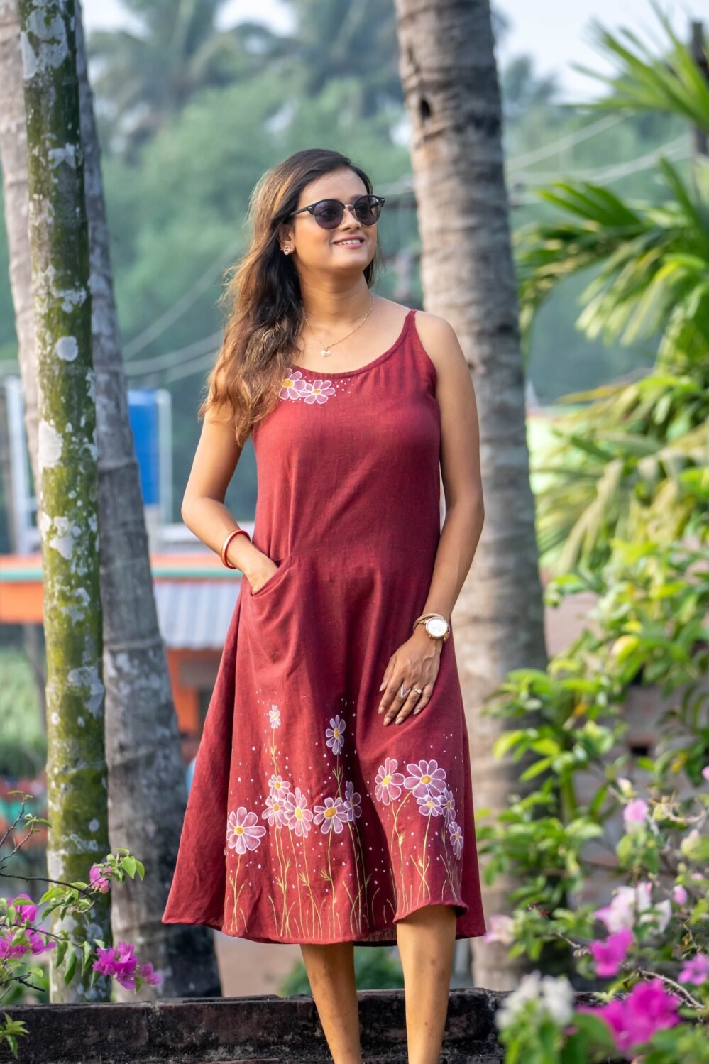 Three-quarter view of hand-painted maroon dress highlighting the functional side pocket and A-line flair