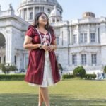 Full-length outdoor shot of Mridu hand-painted maroon cotton dress with layered skirt.