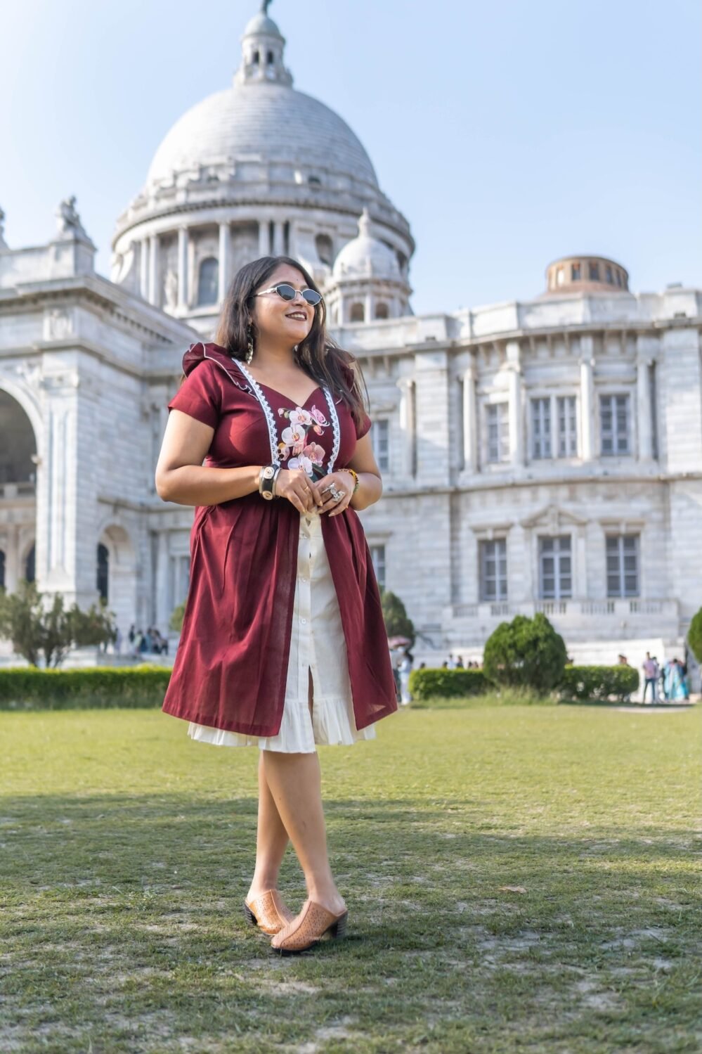 Full-length outdoor shot of Mridu hand-painted maroon cotton dress with layered skirt.