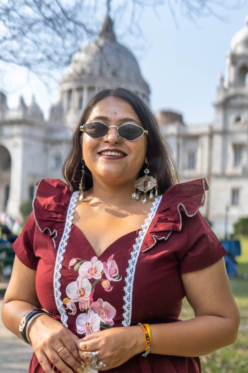 Portrait view of Mridu hand-painted floral maroon cotton dress with lace trim.