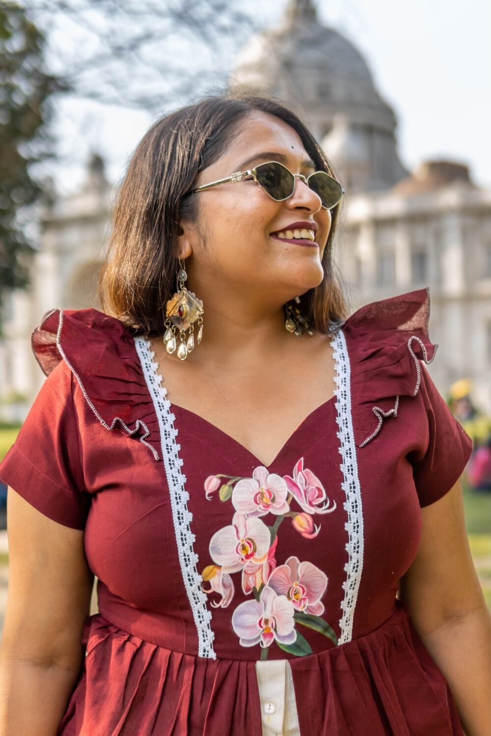 Close-up of hand-painted orchid flowers on the bodice of Mridu maroon cotton dress.