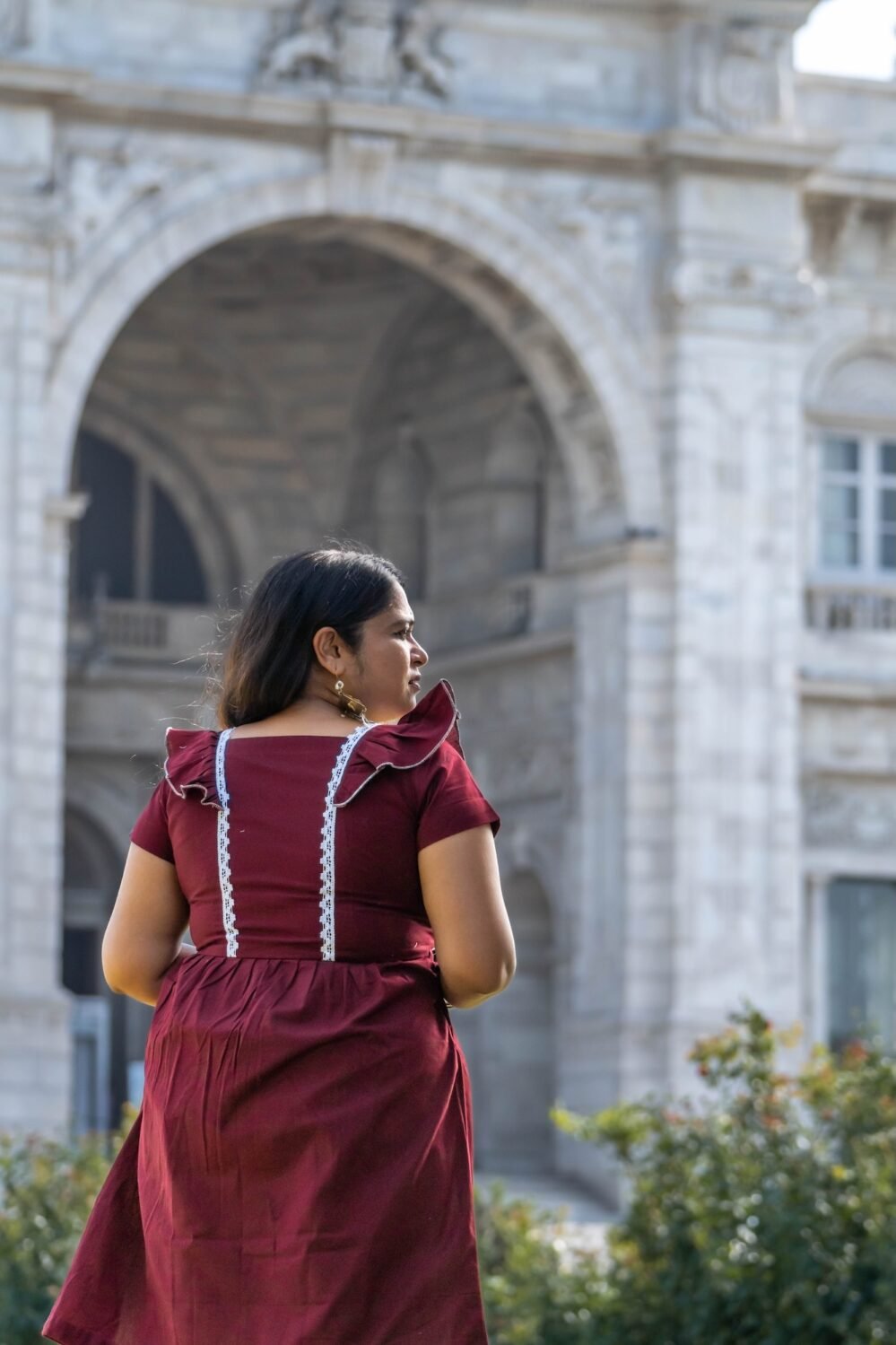 Back view showing ruffle shoulder details and white lace trims of Mridu dress.