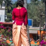 Back view of the Nayantara co-ord set showing the fit, curved hemline of the magenta top, and draped peach dhoti pants