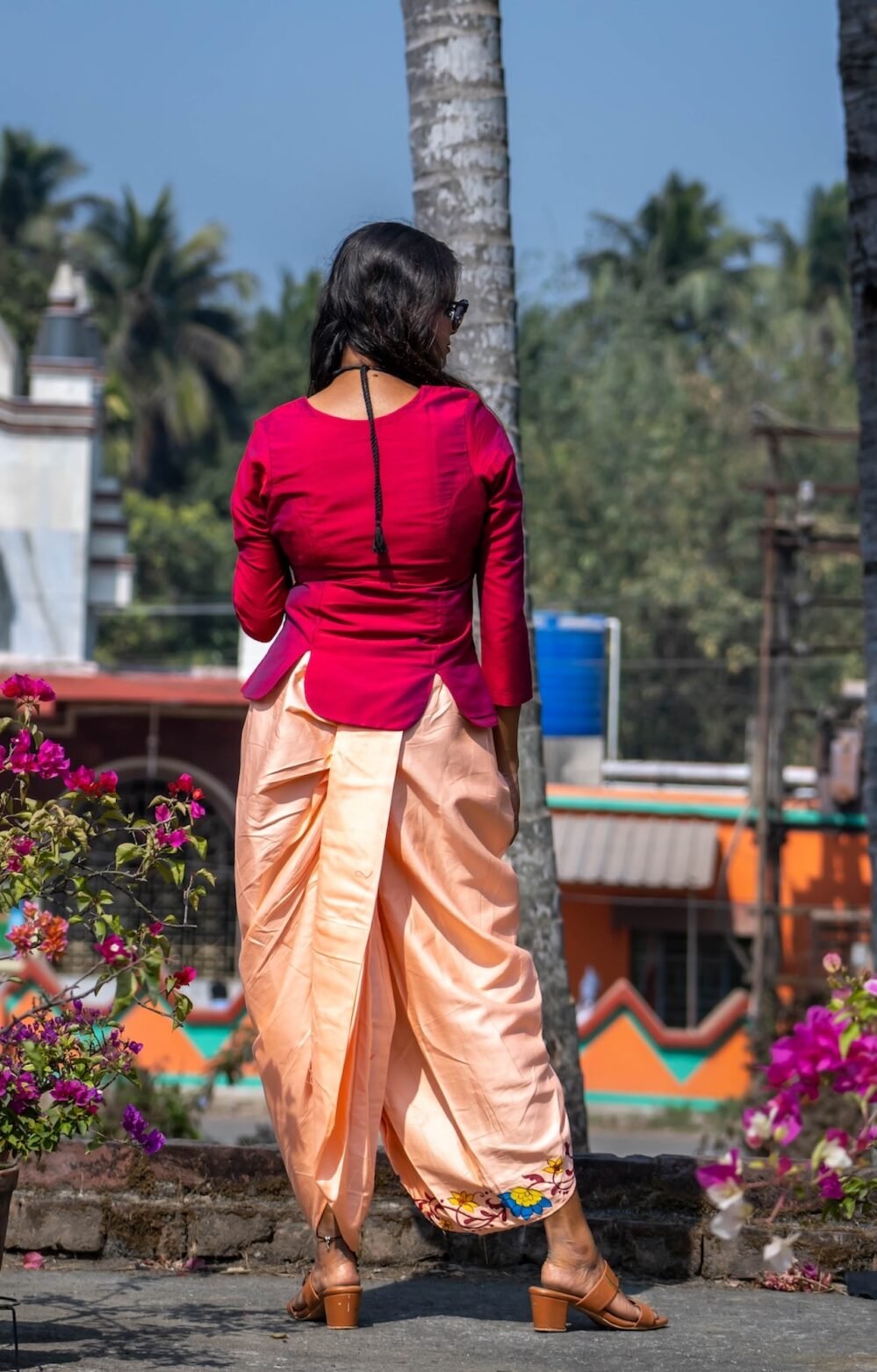 Back view of the Nayantara co-ord set showing the fit, curved hemline of the magenta top, and draped peach dhoti pants