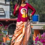 Outdoor shot of model wearing the complete Nayantara hand-painted magenta top and peach dhoti co-ord set