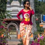 Model standing in a traditional outdoor setting wearing the Nayantara hand-painted fusion dhoti set