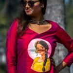 Close-up view of the hand-painted portrait motif on the deep magenta V-neck top from the Nayantara collection