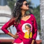 Waist-up shot of model wearing the V-neck magenta top with hand-painted portrait artwork and cotton lining