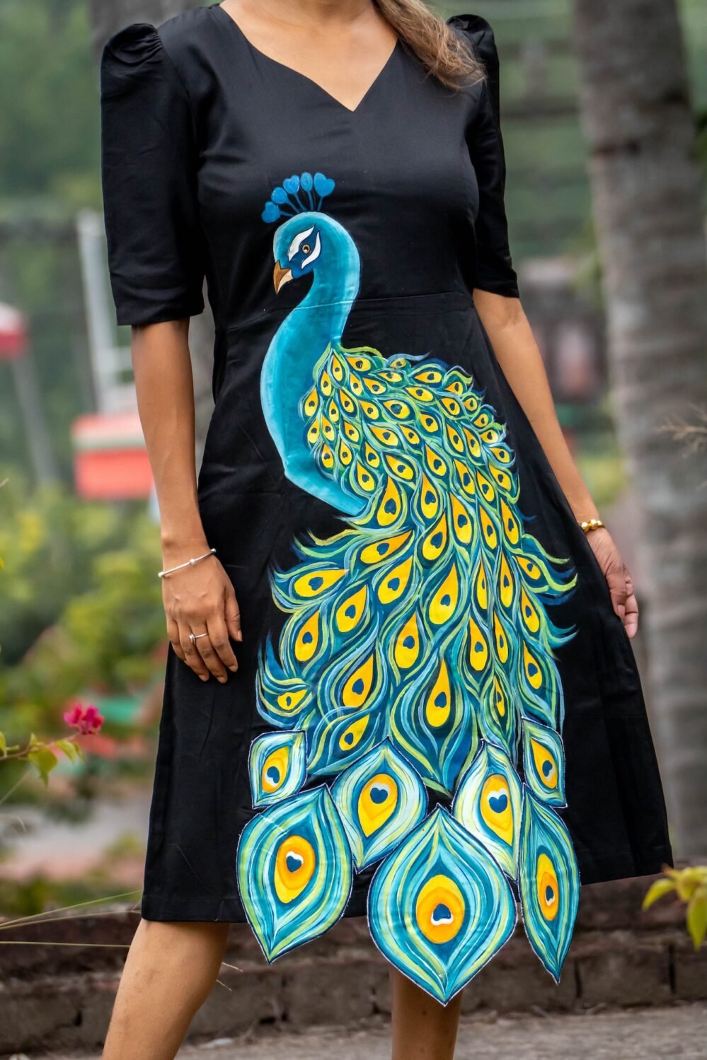 Detailed view of hand painted peacock artwork on soft black Malai Cotton fabric
