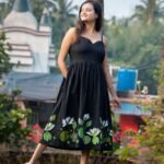 Full length view of black hand-painted water lily flared midi dress with green lotus pad artwork