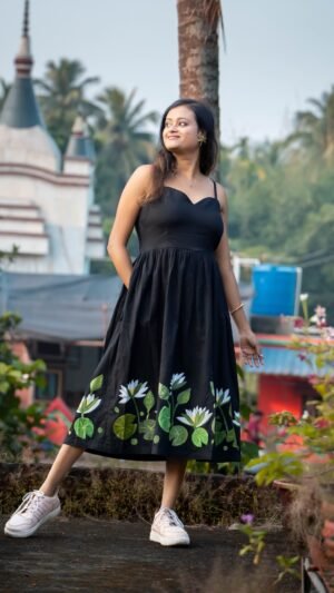 Full length view of black hand-painted water lily flared midi dress with green lotus pad artwork