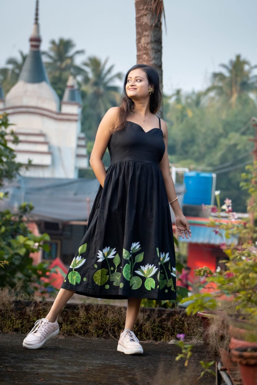 Full length view of black hand-painted water lily flared midi dress with green lotus pad artwork