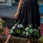 Angle shot displaying hand-painted white water lilies with vibrant green stems along the hemline