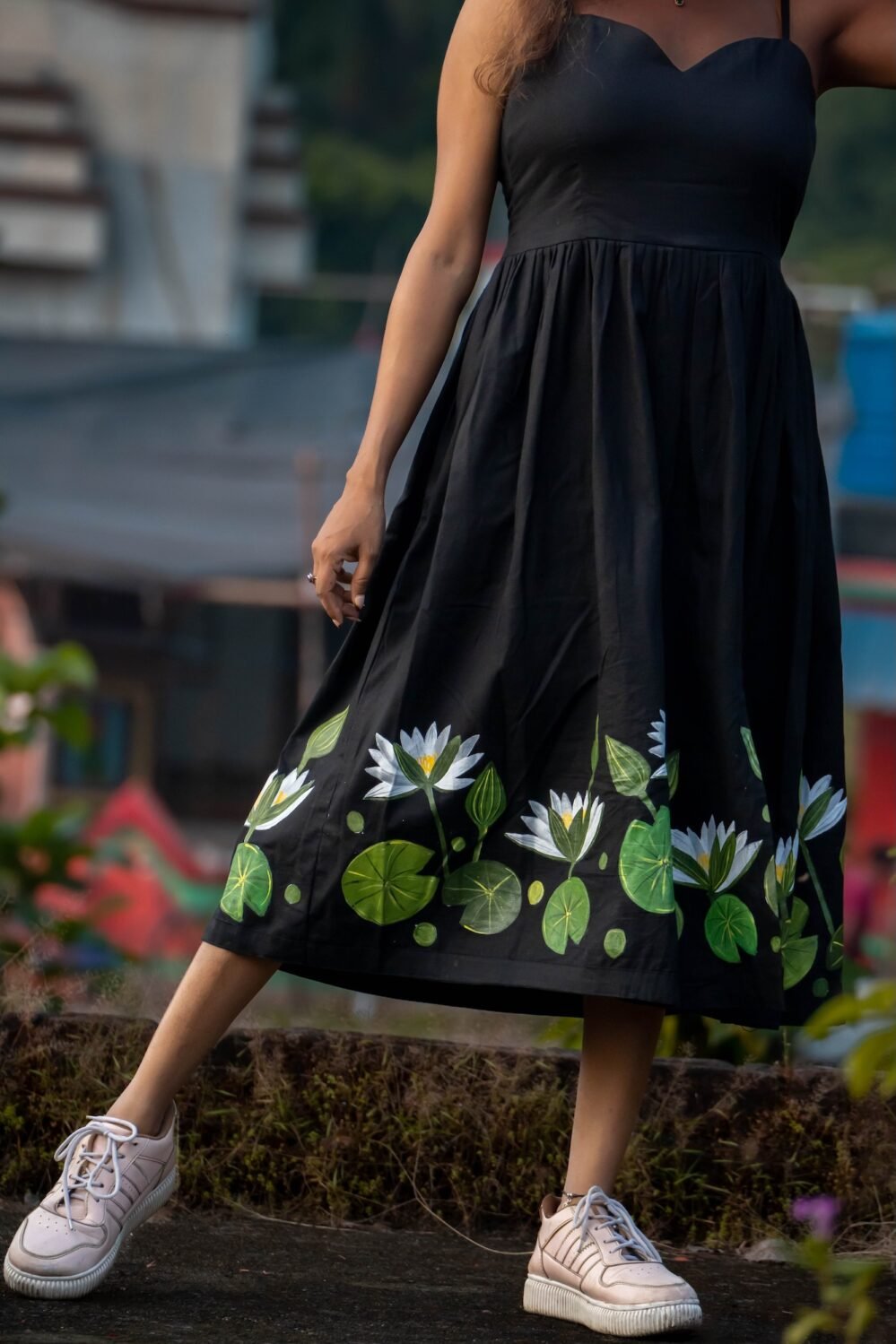 Angle shot displaying hand-painted white water lilies with vibrant green stems along the hemline