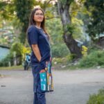 Side view of the straight-fit navy blue cotton tunic and matching straight pants worn outdoors.