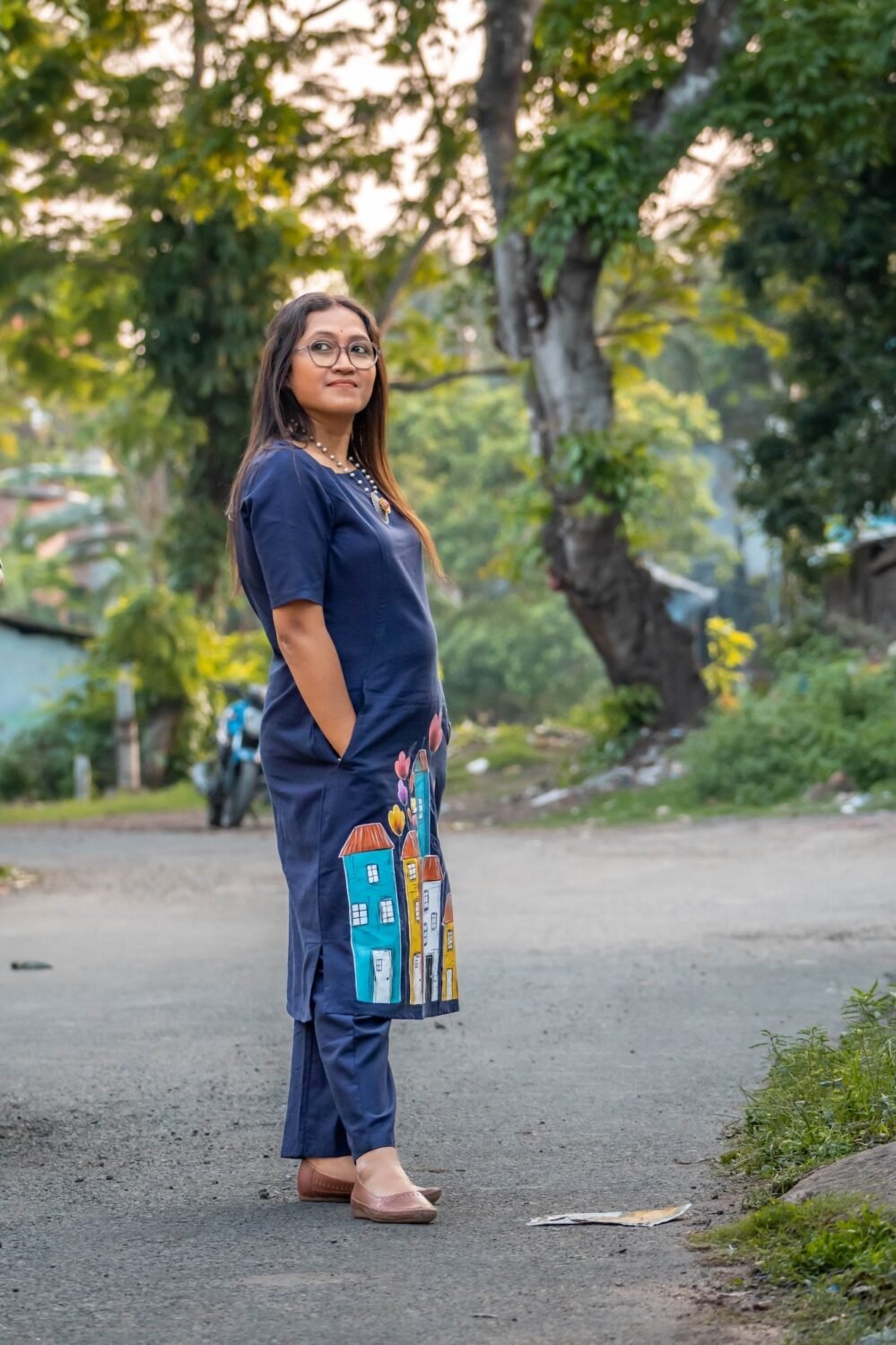 Side view of the straight-fit navy blue cotton tunic and matching straight pants worn outdoors.