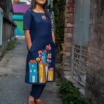 Full view of the straight-fit navy blue cotton tunic and matching straight pants worn outdoors.