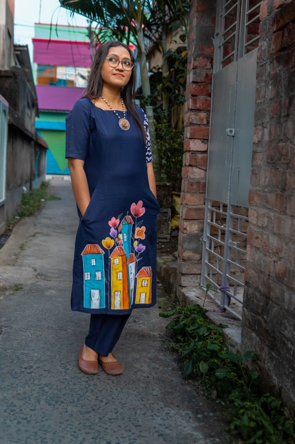 Full view of the straight-fit navy blue cotton tunic and matching straight pants worn outdoors.