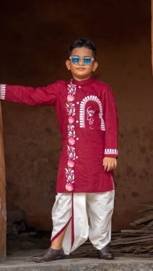 Boy standing in a traditional doorway wearing a maroon hand painted Durga motif kurta with an off-white dhoti.