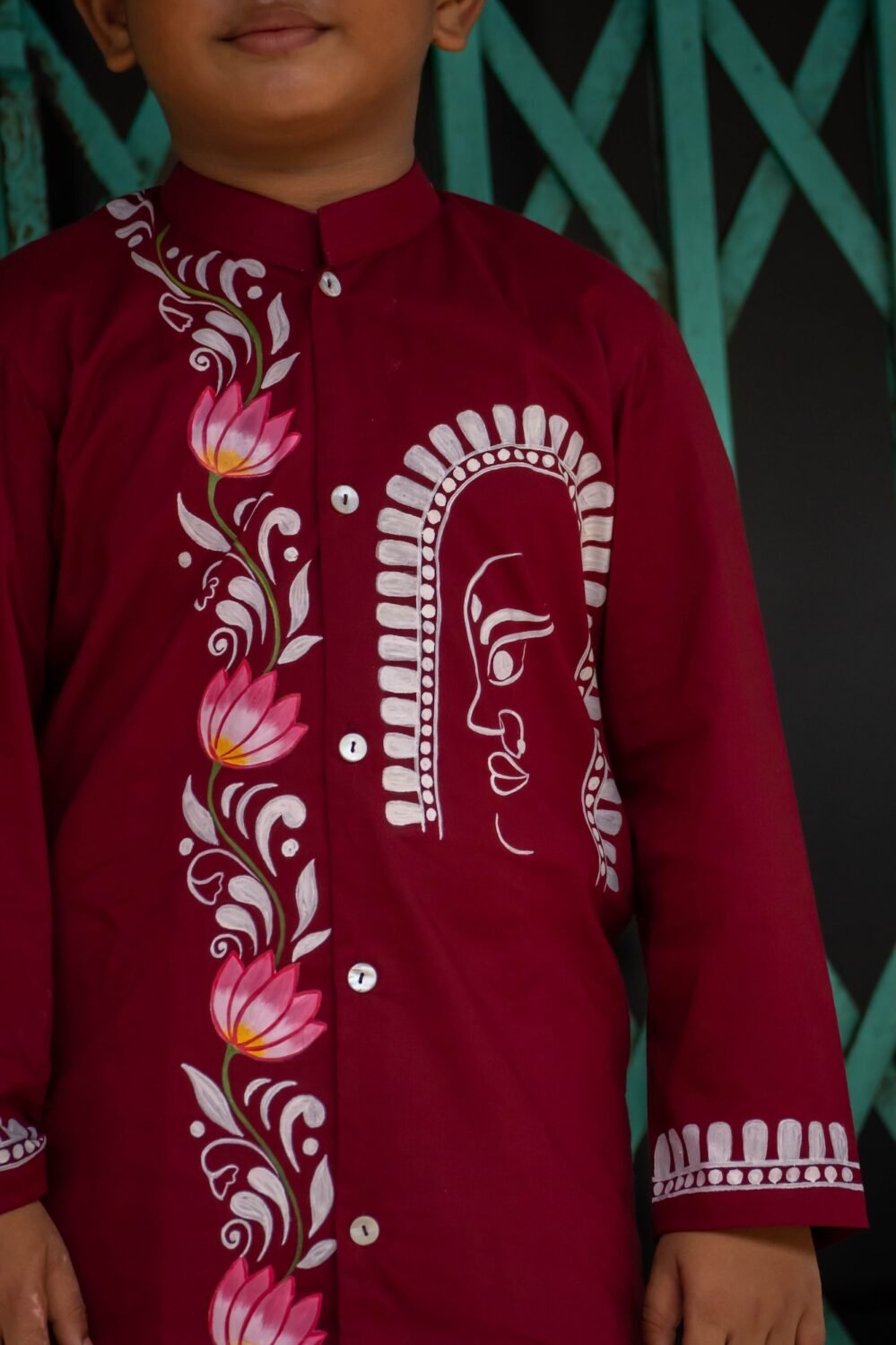 Close-up of the hand-painted line art Durga motif and pink lotus vine on the chest of the maroon boys' kurta.