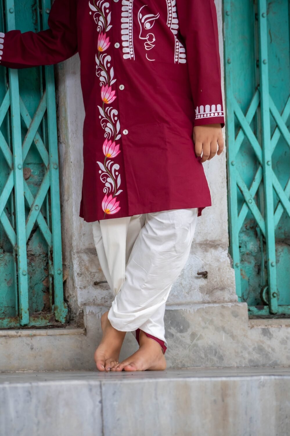 Detailed lower-body shot showing the off-white cotton dhoti paired with the hand-painted maroon lotus vine kurta for boys.