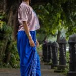 Side angle of CharuNeela 3-piece set styling royal blue dhoti with lightweight beige jacket
